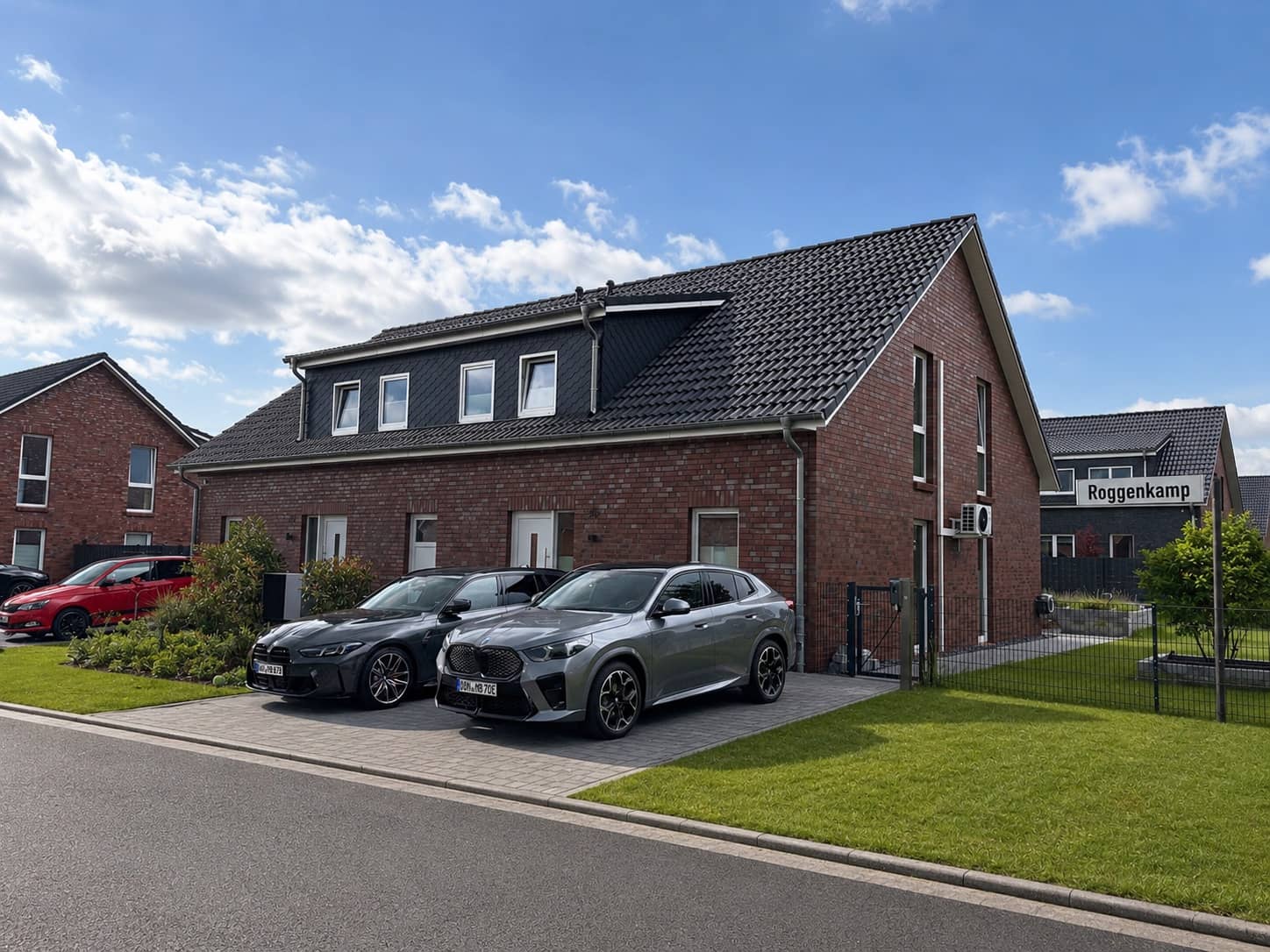 Straßenansicht des Doppelhauses mit Stellplätzen